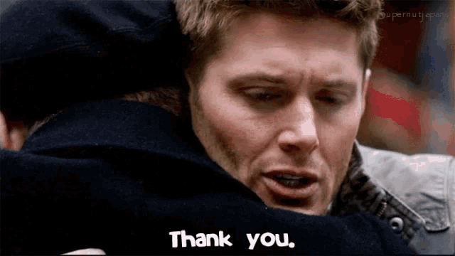 a man hugging another man with the words thank you on the bottom right