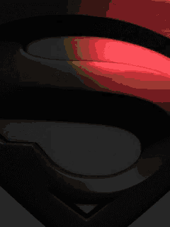 a close up of a superman logo with a yellow light coming out of it