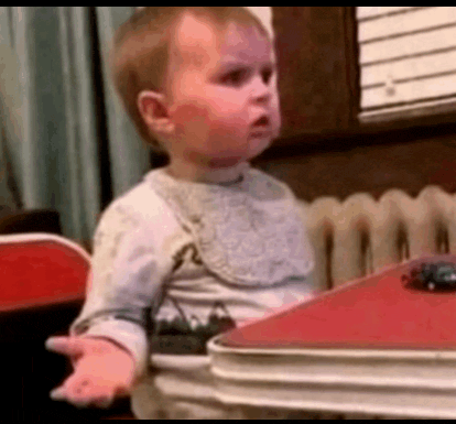 a baby is sitting at a table with a toy car on top of it .