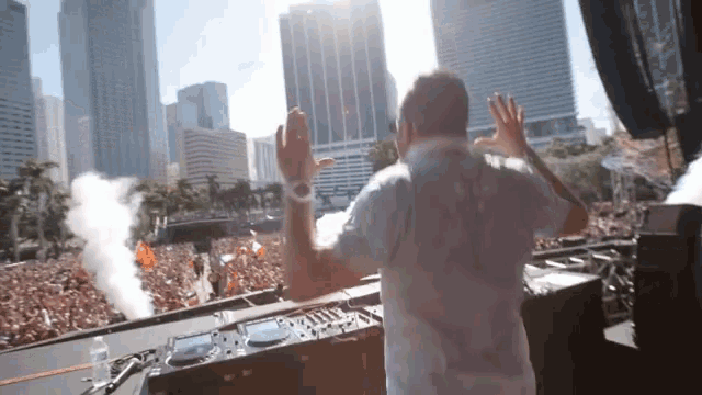 a man in a white shirt stands in front of a crowd
