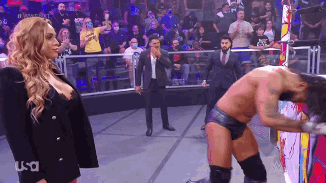 a woman standing next to a man in a wrestling ring with usa written on the screen
