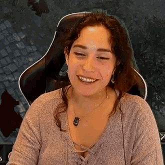 a woman is sitting in a chair and smiling while wearing headphones .