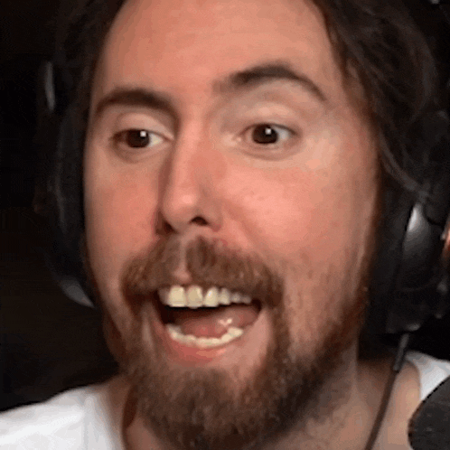 a man with a beard wearing headphones and smiling .