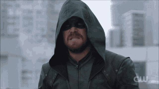 a man wearing a green hooded jacket with the word cw on the bottom
