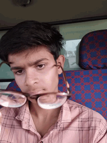 a boy wearing glasses looks at the camera