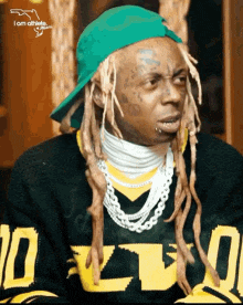 a man with dreadlocks is wearing a green hat and a sweater that says dlvo
