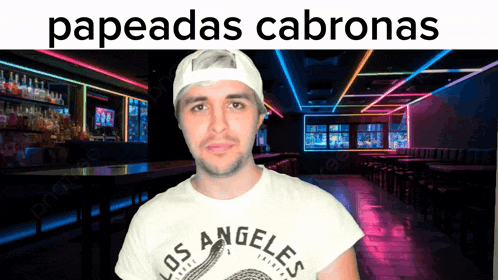 a man wearing a los angeles shirt stands in front of a neon lit room