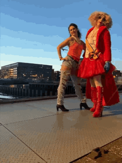 a woman in a red dress stands next to another woman