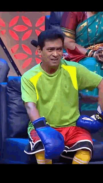 a man is wearing boxing gloves and a green shirt