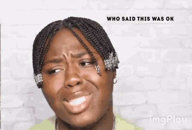 a woman making a funny face with the words who said this was ok behind her