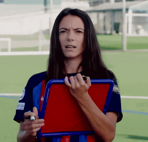 a woman wearing a nike shirt holds a clipboard