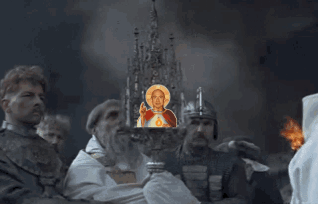 a man holding a statue of jesus in front of a fire