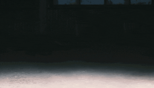 a man in a hooded sweatshirt is running in the dark