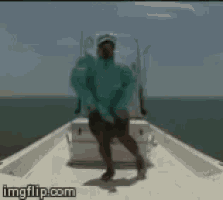 a man in a blue jacket is standing on the back of a boat with imgflip.com written below him