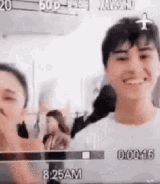 a man and a woman are standing next to each other on a video camera .
