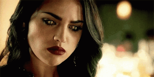a close up of a woman 's face with red lips and a serious look on her face .