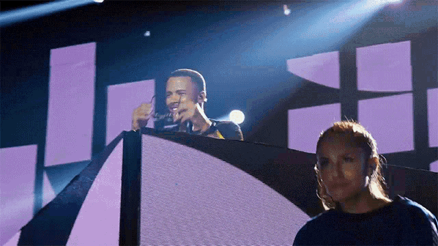 a man singing into a microphone on a stage