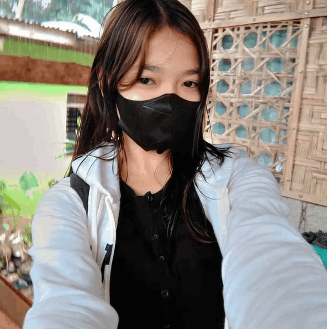 a girl wearing a black mask and a white jacket with the number 7 on the sleeve