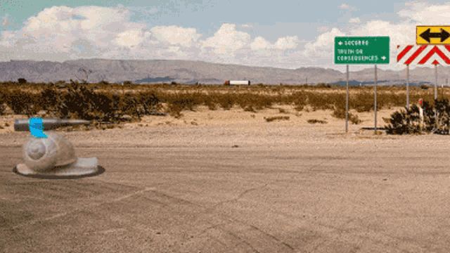 a green sign on the side of a road says truth or consequences on it