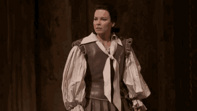 a woman wearing a white shirt and a gray vest