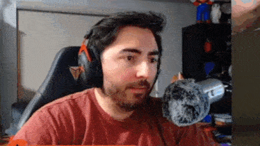 a man with a beard wearing headphones and a microphone .