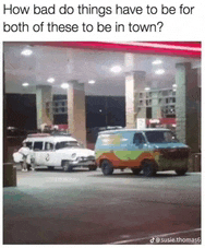 a scooby doo van is parked next to a ghostbusters car at a gas station