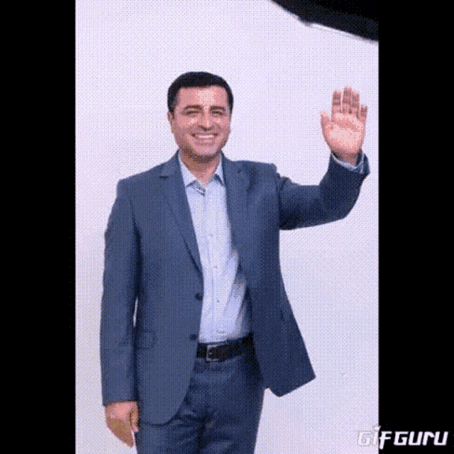 a man in a suit is waving his hand in front of a white background