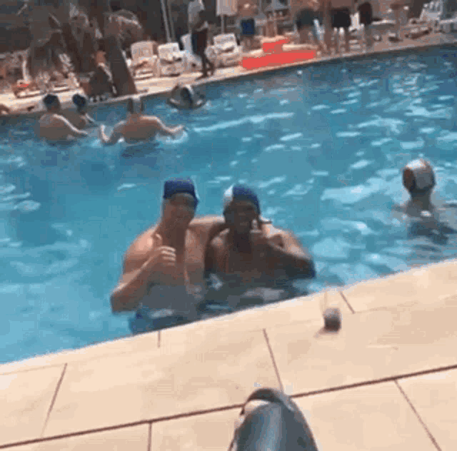 a group of people are swimming in a pool .