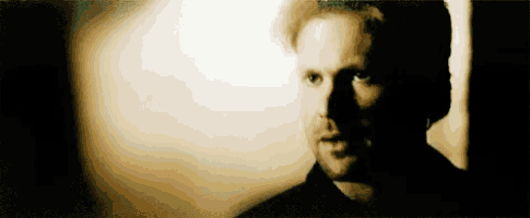 a close up of a man 's face in a dark room with a shadow on his face .