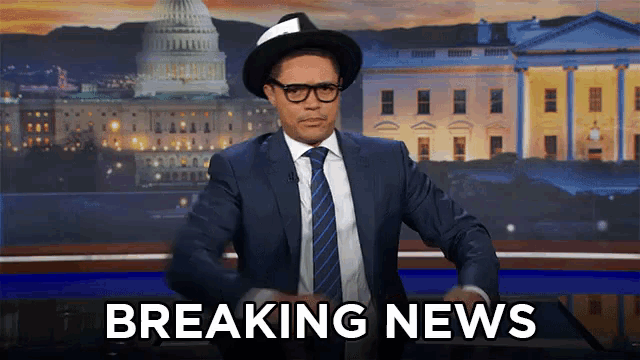 a man in a suit and tie says breaking news in front of the capitol building
