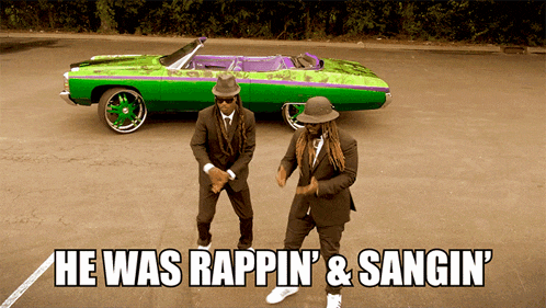 two men in suits are dancing in front of a green car that says he was rappin & sangin