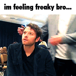 a man in a black jacket is sitting in front of a crowd and the caption says im feeling freaky bro