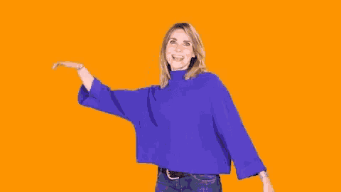 a woman in a blue sweater is waving her hand .