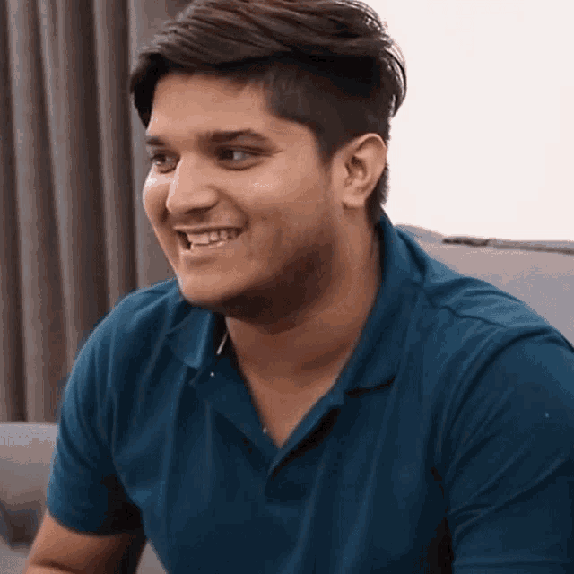 a young man in a blue shirt is smiling