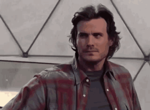 a man in a plaid shirt is standing in front of a white dome .