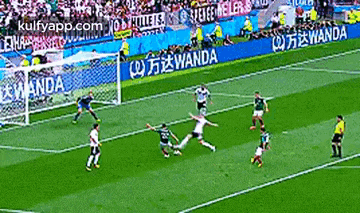 a group of soccer players are playing on a field with wanda advertisements on the sidelines