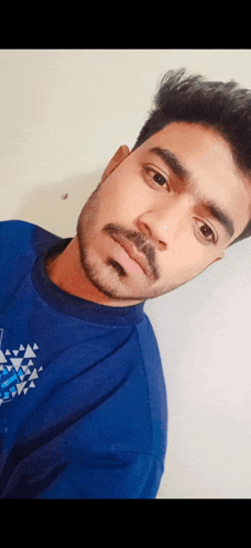 a man with a beard is wearing a blue shirt that says adidas on it