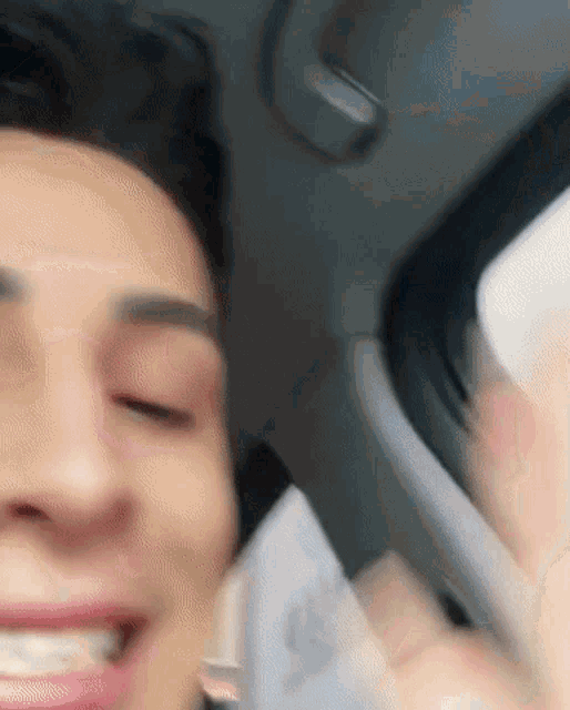 a close up of a man 's face in a car with his eyes closed