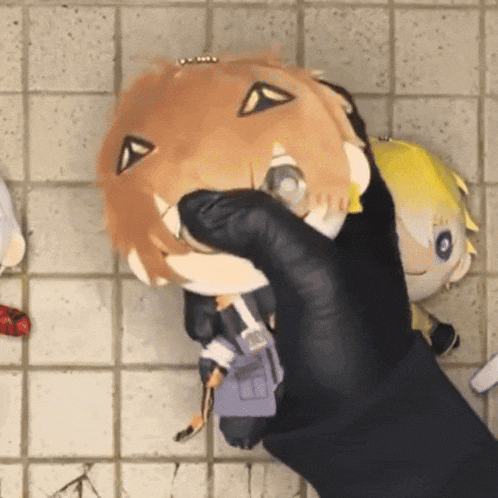 a person is holding a stuffed animal with a triangle on its face