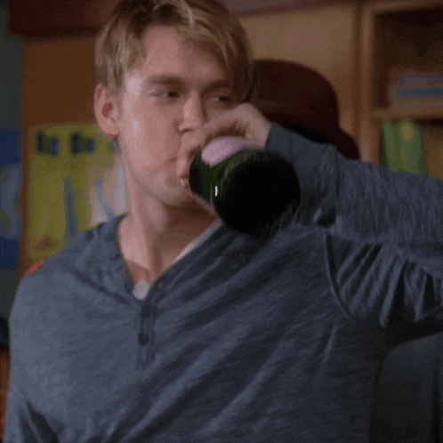 a man is drinking from a bottle that says new director on it