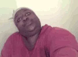 a man in a red shirt is taking a selfie with his head down .