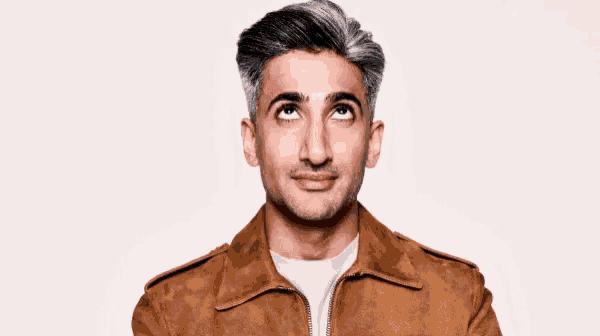 a man with gray hair and a brown jacket is looking up at the sky .