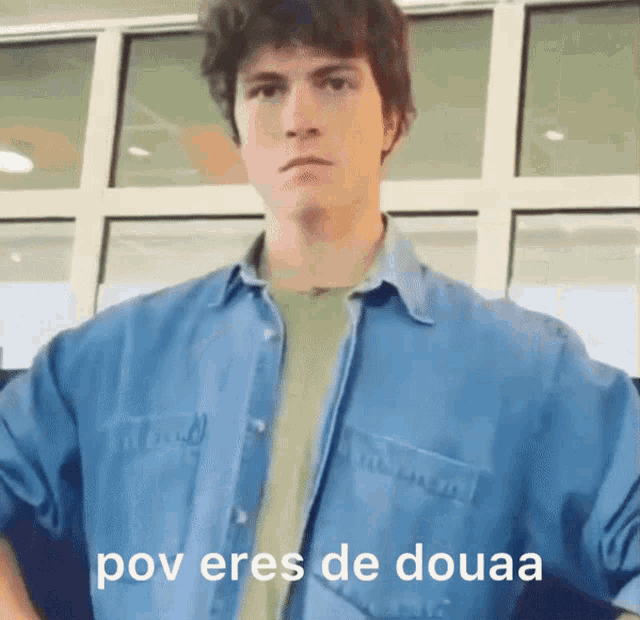 a man wearing a blue shirt with the words pov eres de douaa on the bottom