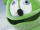 a close up of a green gummy bear with big blue eyes .