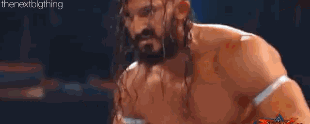 two men are wrestling in a ring and one of them is jumping in the air