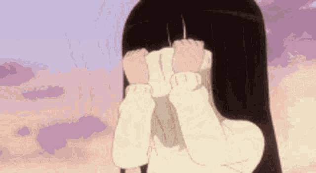 a girl with long black hair is covering her face with a sweater .