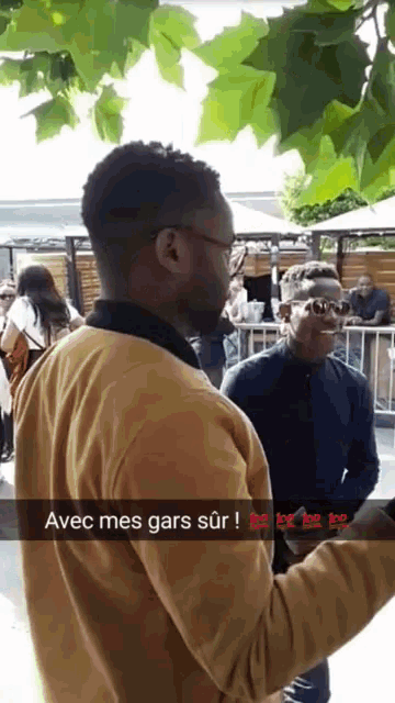 a man taking a picture of another man with a caption that says avec mes gars sur
