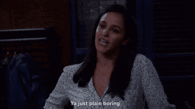 a woman in a floral shirt is sitting down and talking .
