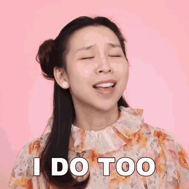 a woman in a floral dress says i do too with her eyes closed