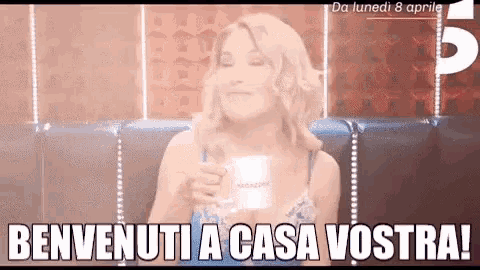 a woman is holding a cup of coffee in her hand and says benvenuti a casa vostra !